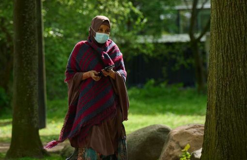 Kvinna med munskydd promenerar i park