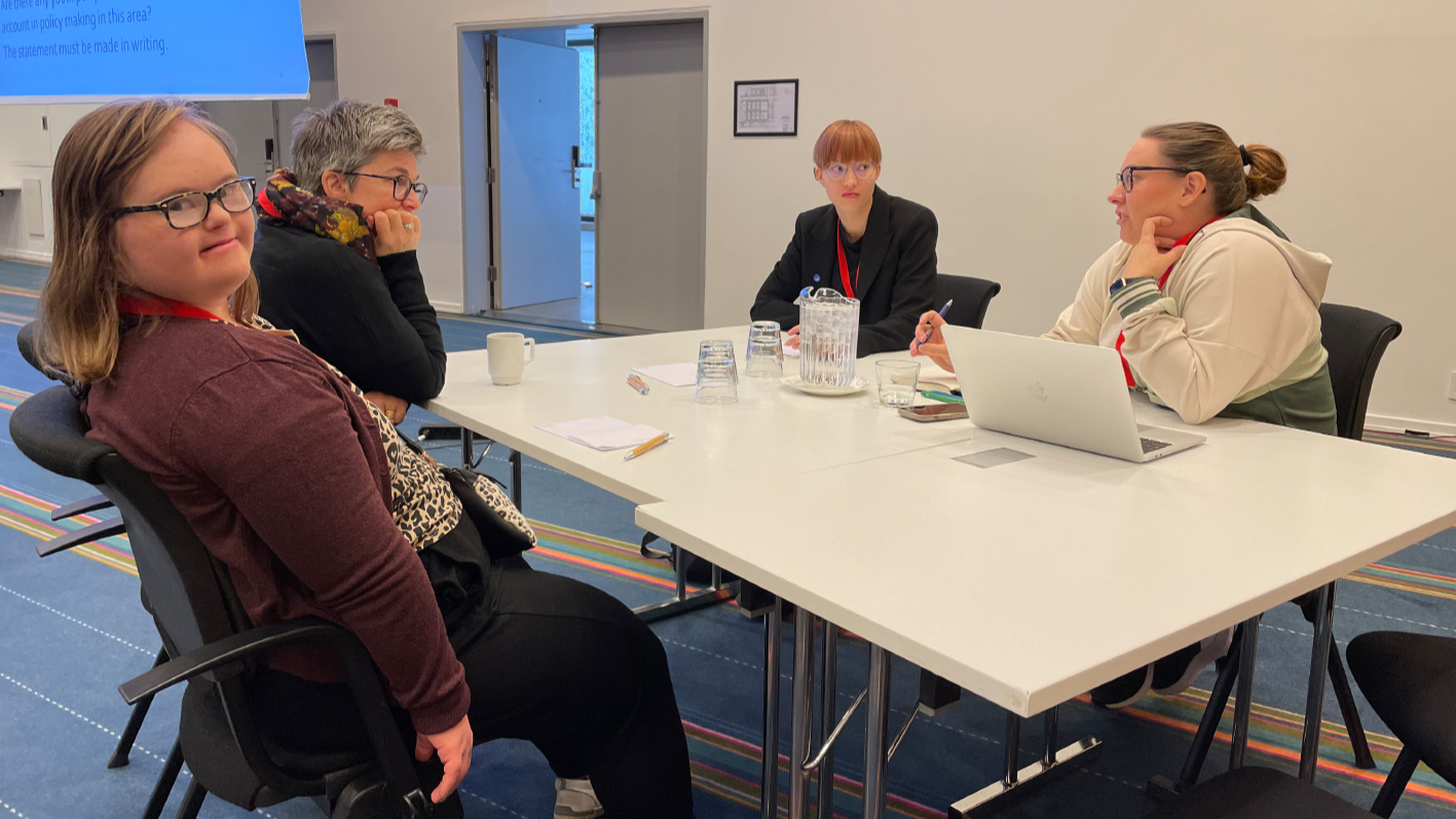 Four participants sitting around a table having a discussion