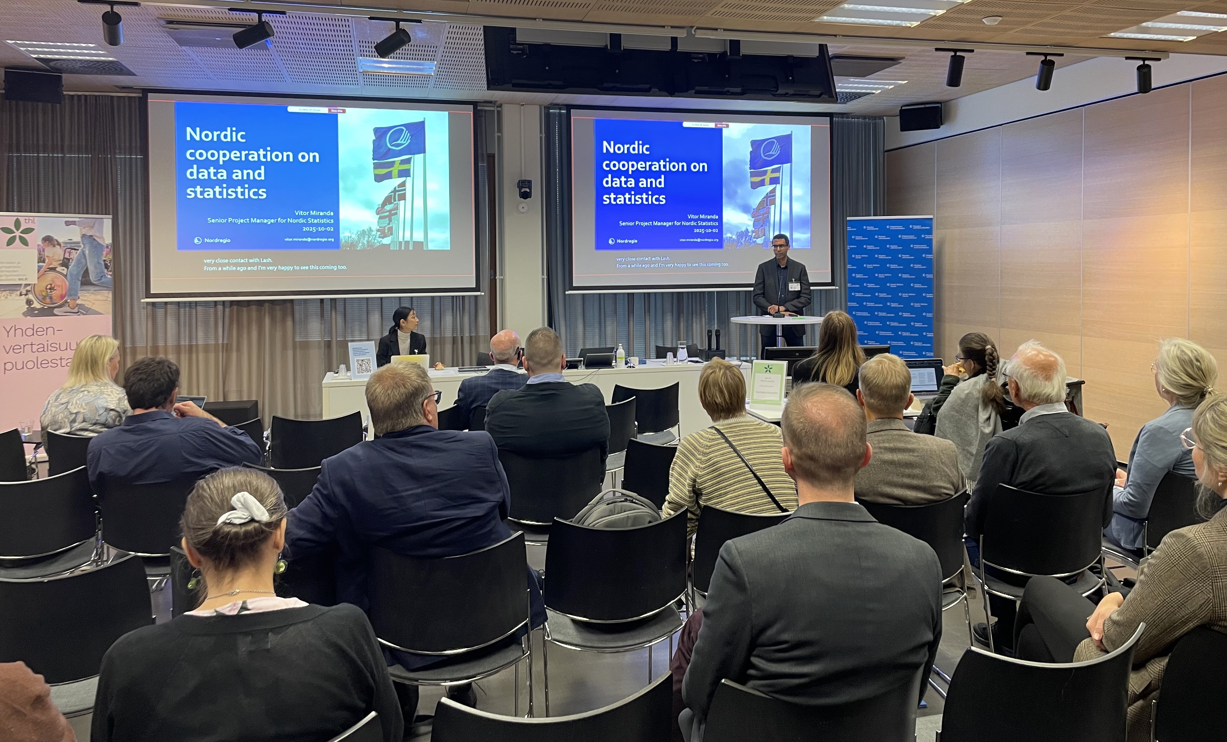 En mann som holder en presentasjon i et konferanserom.