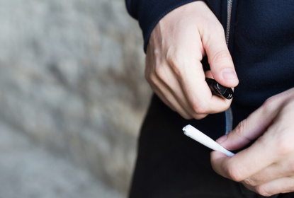 En person tänder en joint.