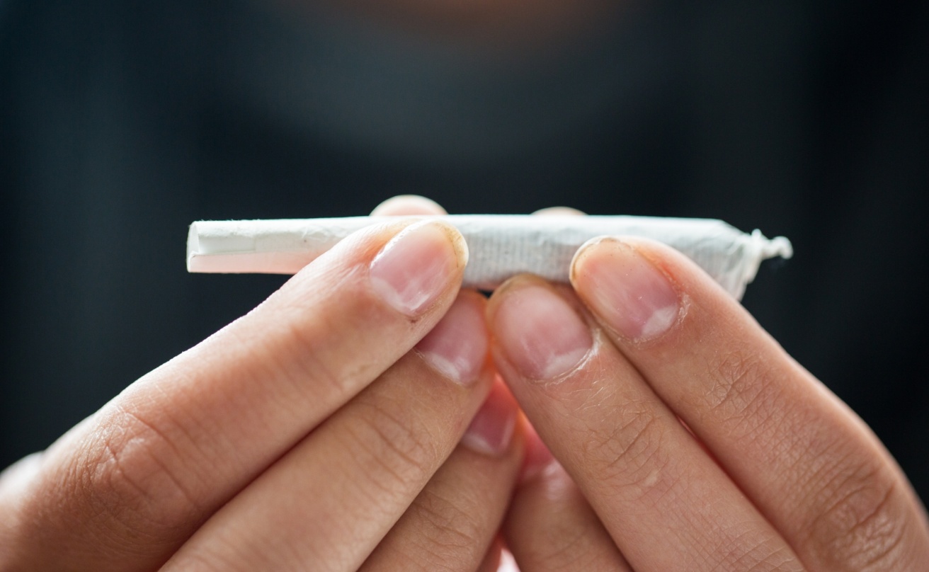 16893252-close-up-of-addict-hands-with-marijuana-joint