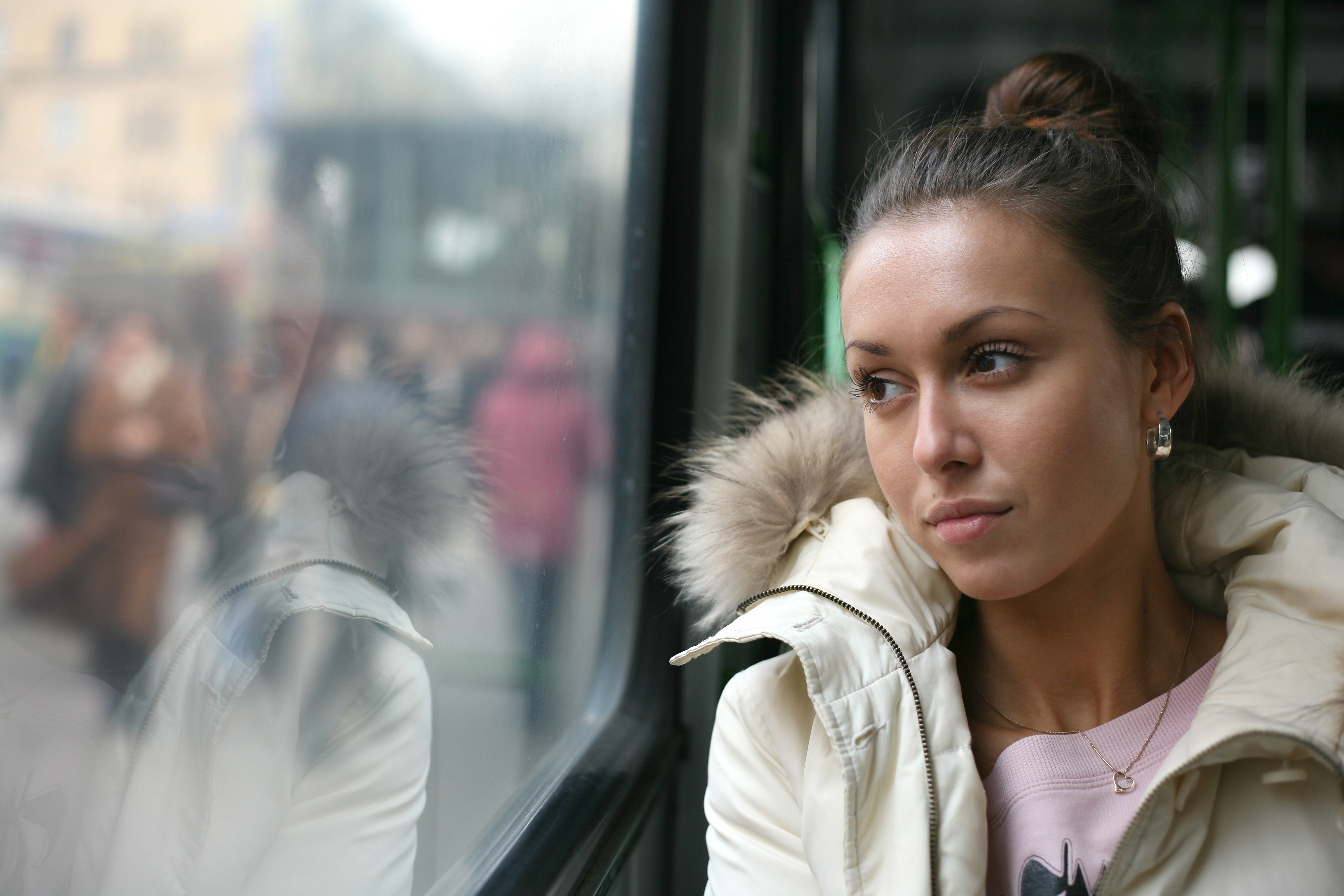 Ung kvinna tittar ut genom bussfönstret