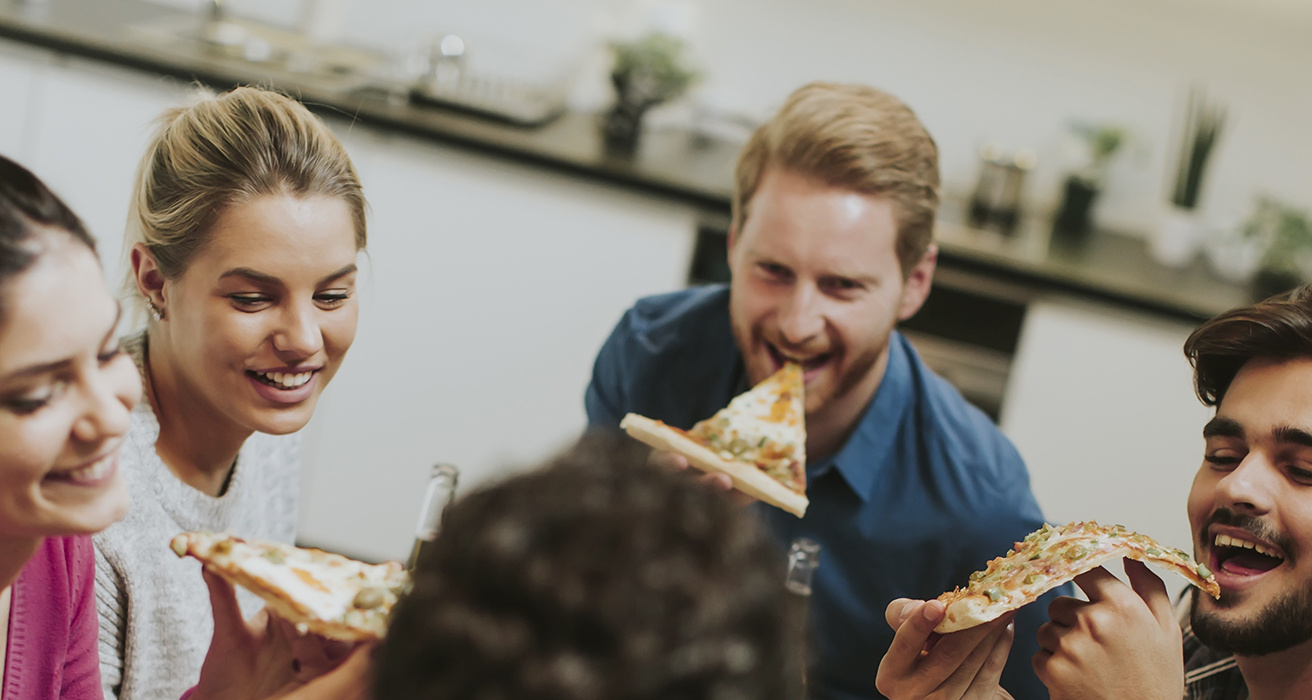 En grupp äter pizza tillsammans.