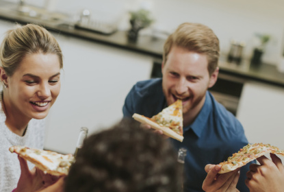 En grupp äter pizza tillsammans.