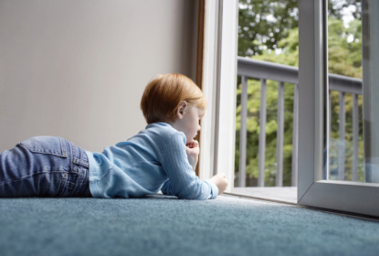 18812605-girl-looking-through-balcony-while-lying-on-carpet%20webb