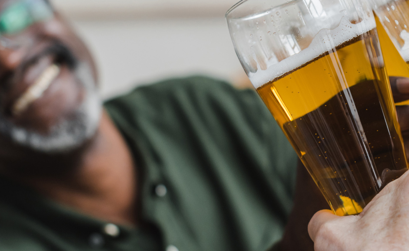 man clinking glasses of beer with friends
