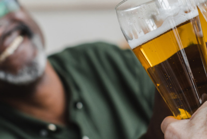 man clinking glasses of beer with friends