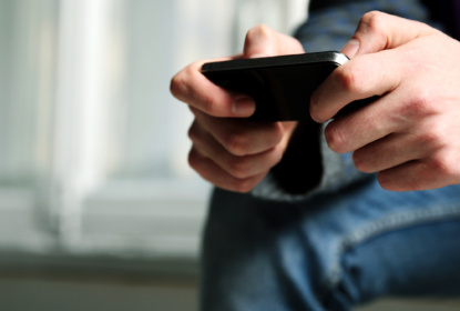En person spelar på sin mobil