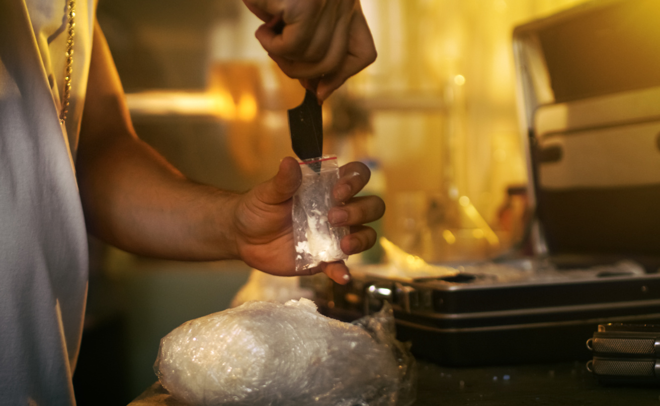 Brutal Drug Dealer Takes Packet Drug Brick out of the Suitcase and Cuts it with a Knife and Packs Sample into Sample Bag. He Squats in the Abandoned Building with Boarded Up Windows.