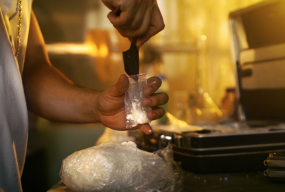 Brutal Drug Dealer Takes Packet Drug Brick out of the Suitcase and Cuts it with a Knife and Packs Sample into Sample Bag. He Squats in the Abandoned Building with Boarded Up Windows.