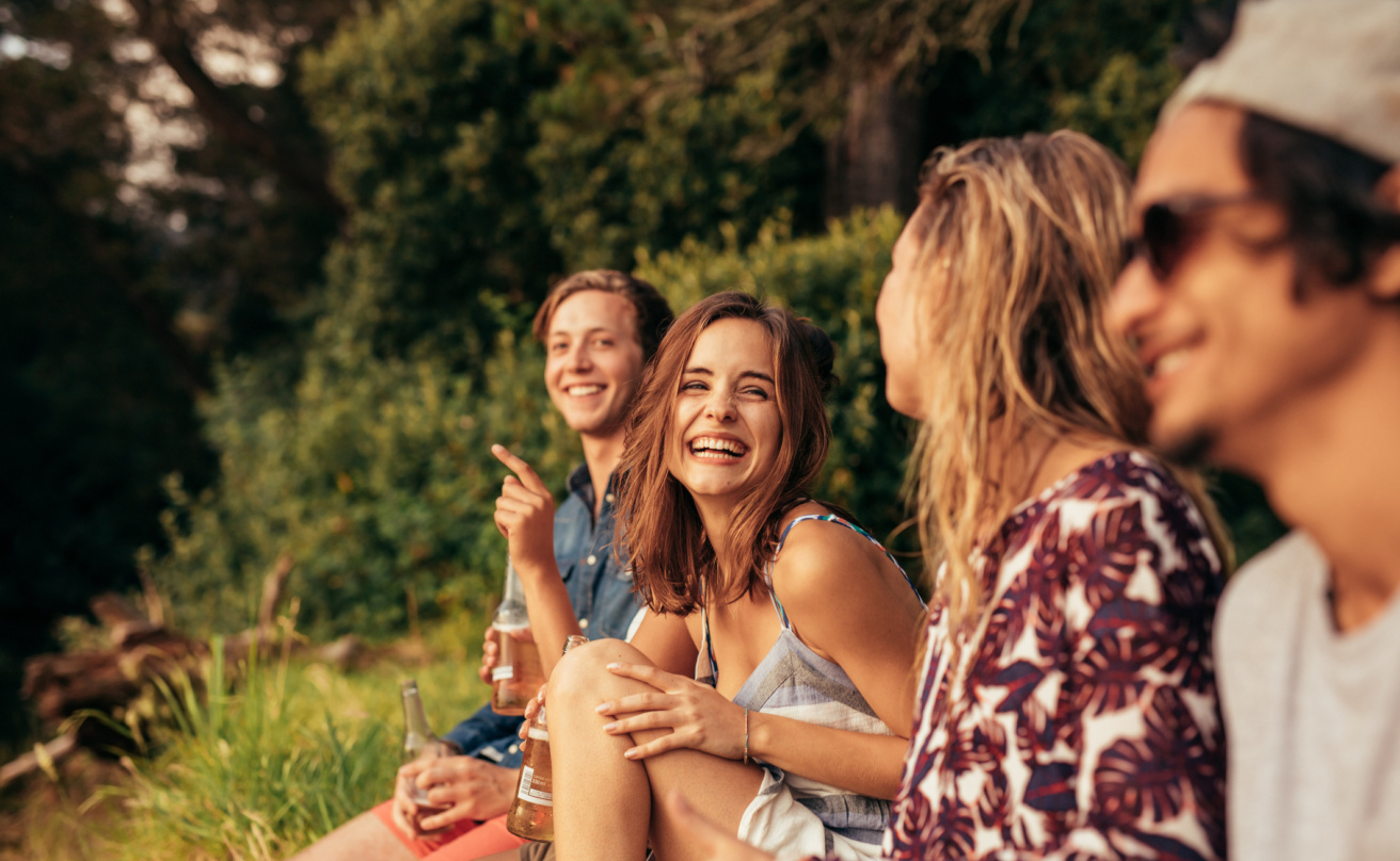 Cheerful young friends hanging out with beers