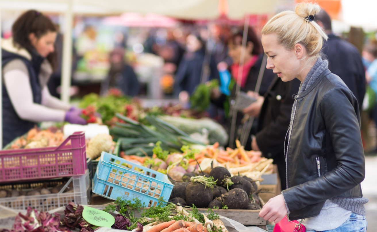 Woman buying vegetable at local food market.