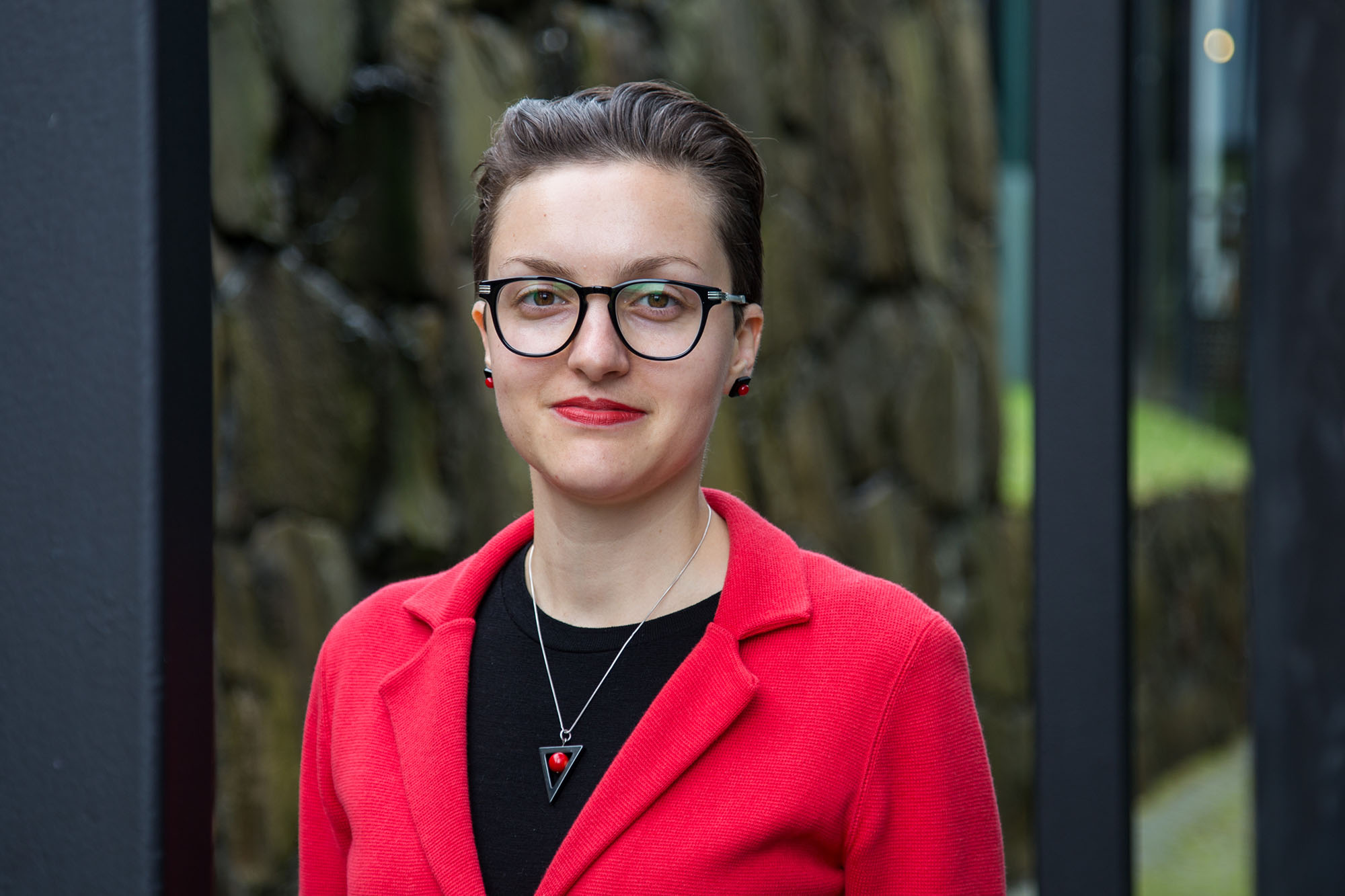 Porträtt av Julia Bahner med röd kavaj och uppsatt hår