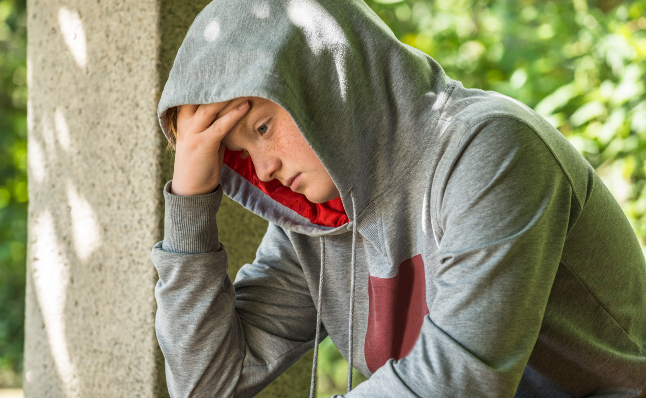 Unhappy boy sitting in a park