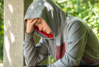 Unhappy boy sitting in a park
