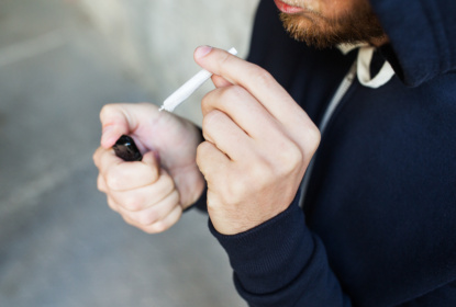 close up of addict smoking marijuana joint