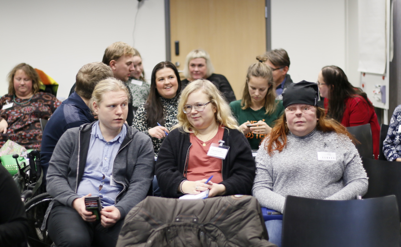 Unga människor med olika former av funktionsnedsättning samlade i en möteslokal