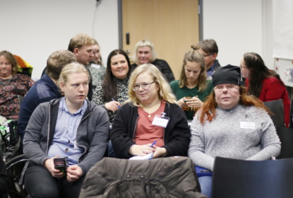 Unga människor med olika former av funktionsnedsättning samlade i en möteslokal