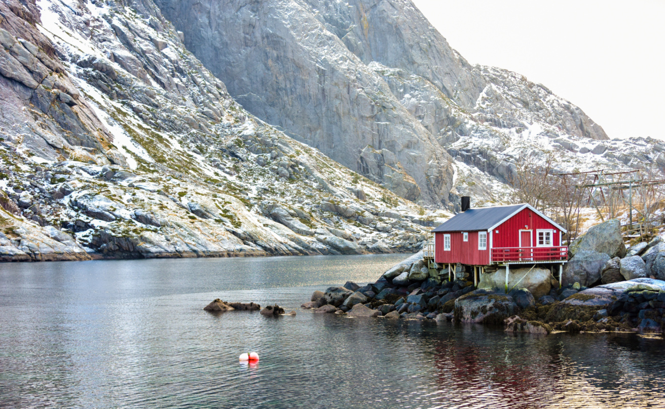 Red cottage near water and mountain
