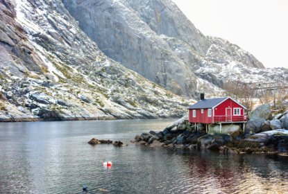 Red cottage near water and mountain