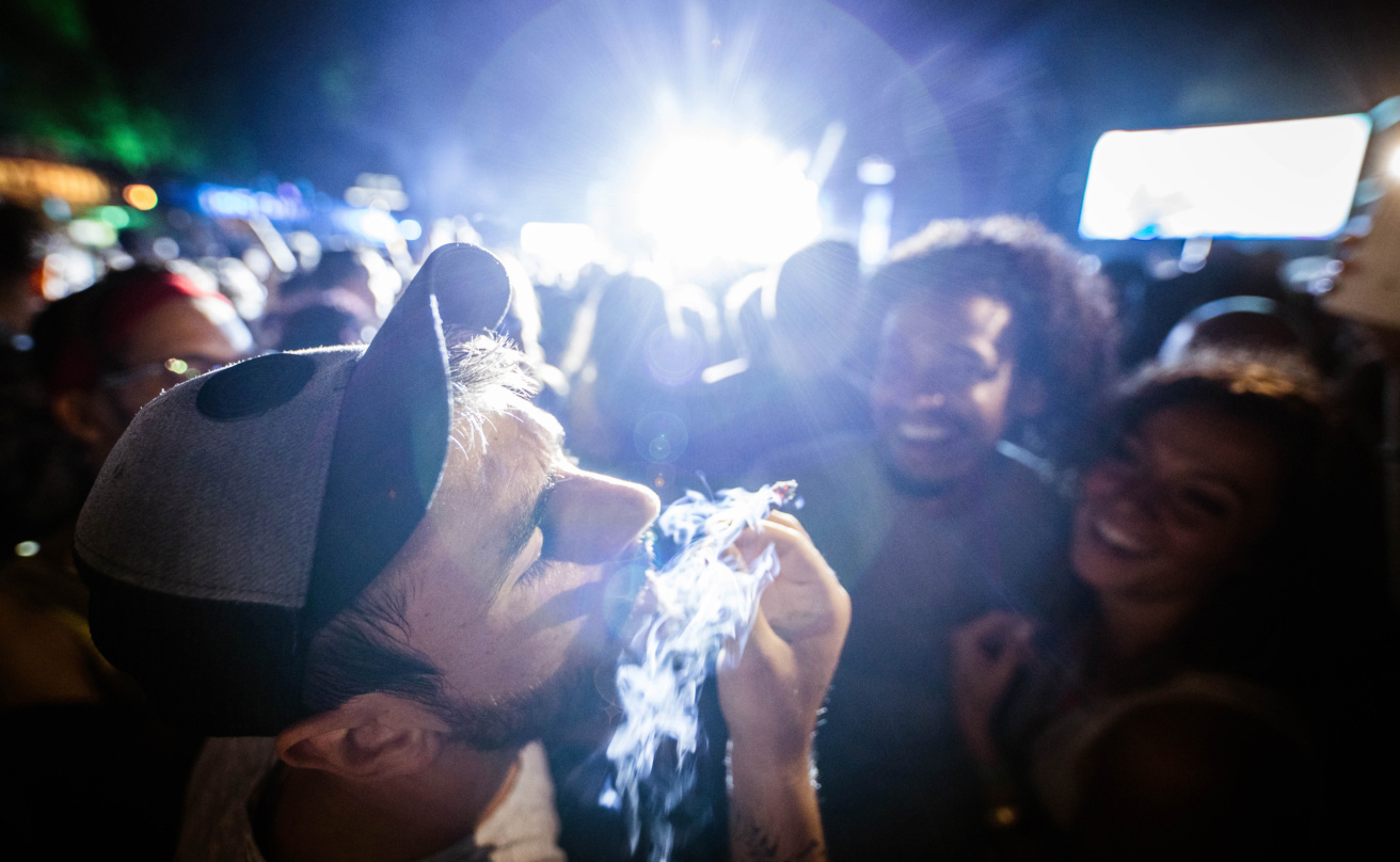 Young man smoking marijuana on a music festival.