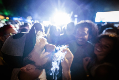 Young man smoking marijuana on a music festival.