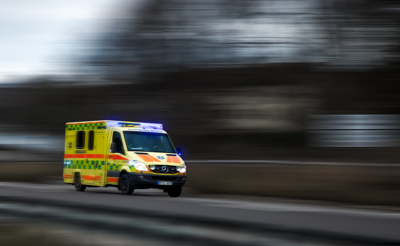 En ambulans i uttryckning som kör i hård fart, med blinkarna på.