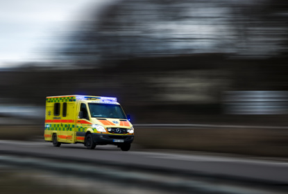 En ambulans i uttryckning som kör i hård fart, med blinkarna på.