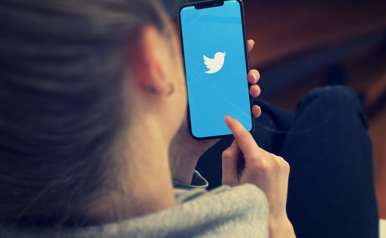 Kvinna använder Twitter på mobiltelefon.