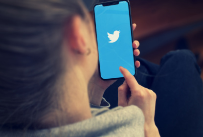 Kvinna använder Twitter på mobiltelefon.