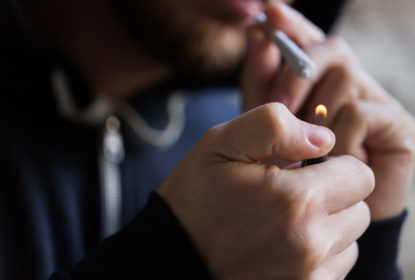 En man tänder en cannabisjoint.