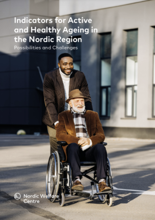 Smiling young man walking outside pushing an old man sitting in a wheelchair.