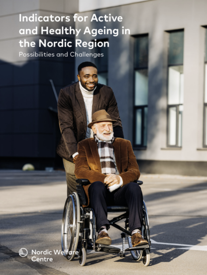 Smiling young man walking outside pushing an old man sitting in a wheelchair.