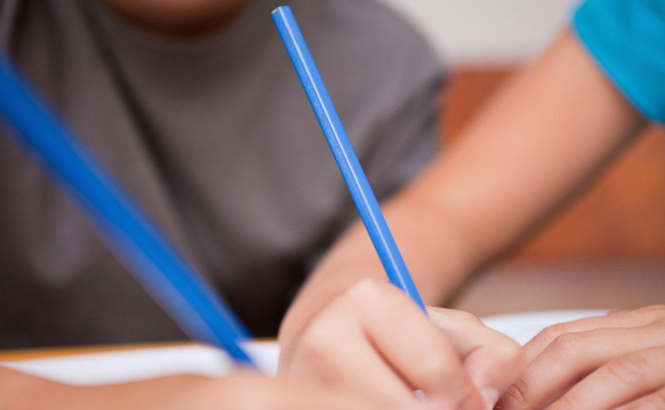 Close-up of two arms holding pens