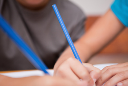 Close-up of two arms holding pens