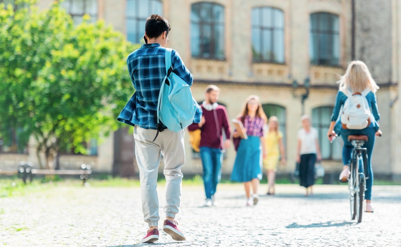27924019-selective-focus-of-students-with-backpacks-on-street