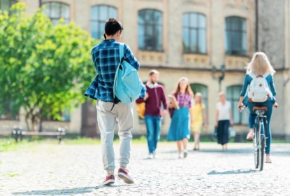 27924019-selective-focus-of-students-with-backpacks-on-street