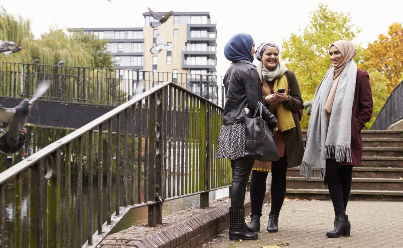 Muslim female friends using mobile phone in urban setting
