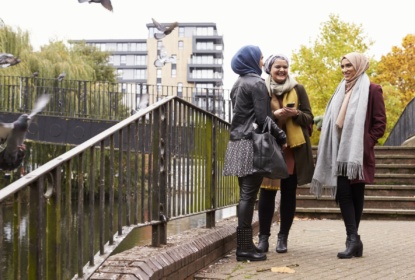 Muslim female friends using mobile phone in urban setting