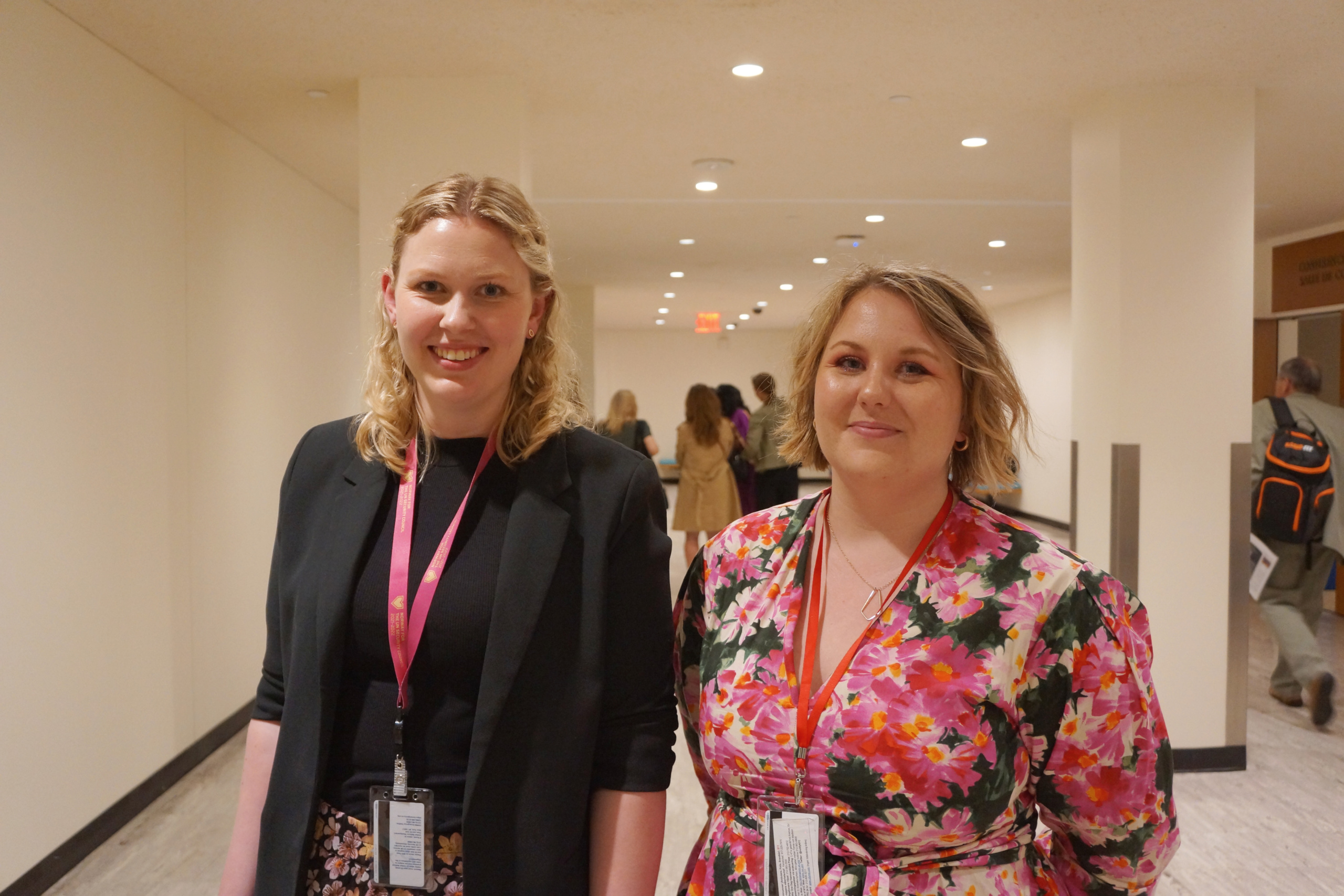 Two young women standing, inside