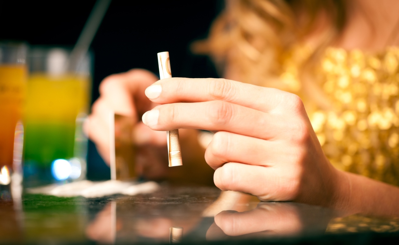 Young woman snorting cocaine