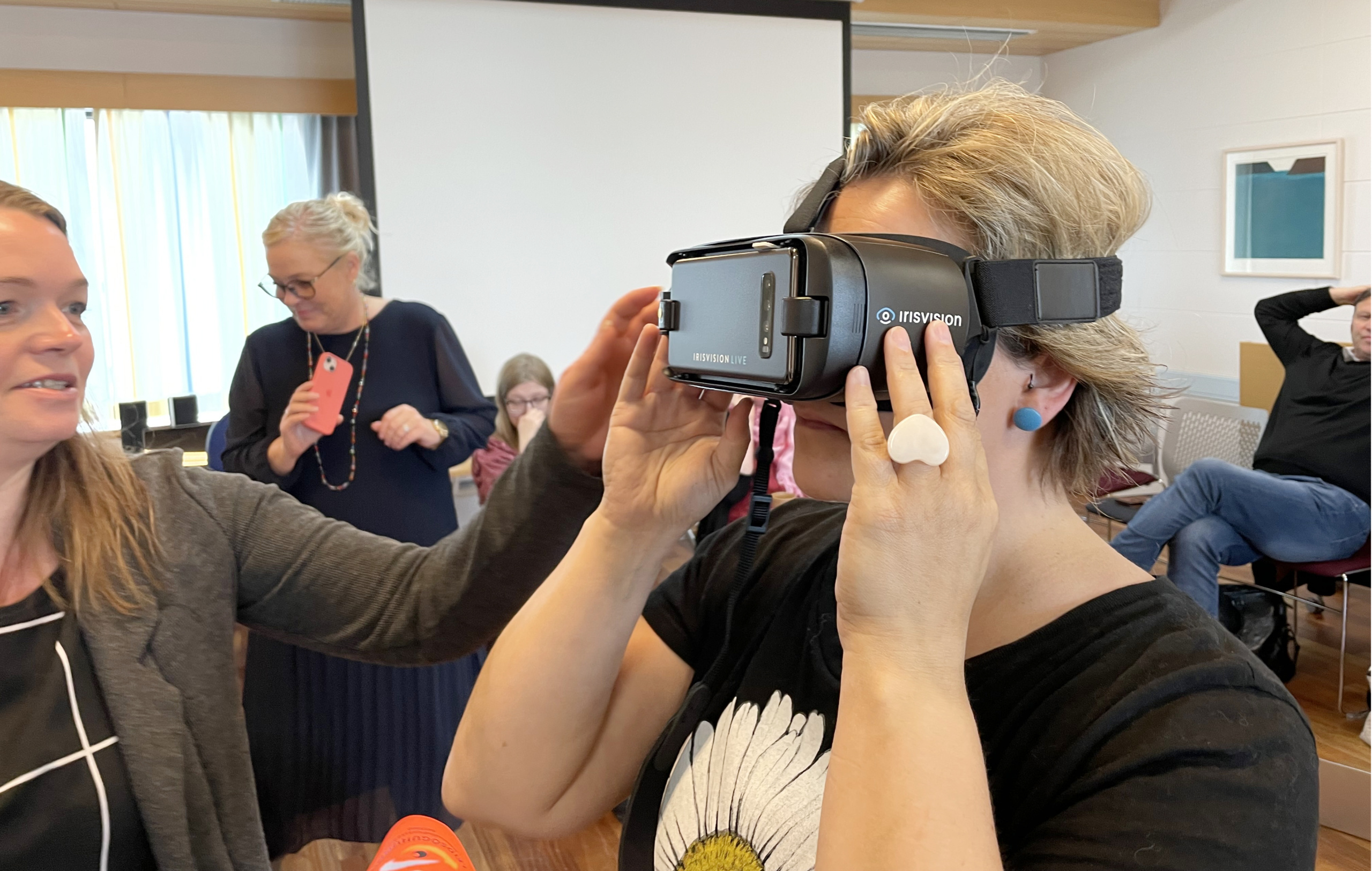 Woman getting help trying on magnifying goggles