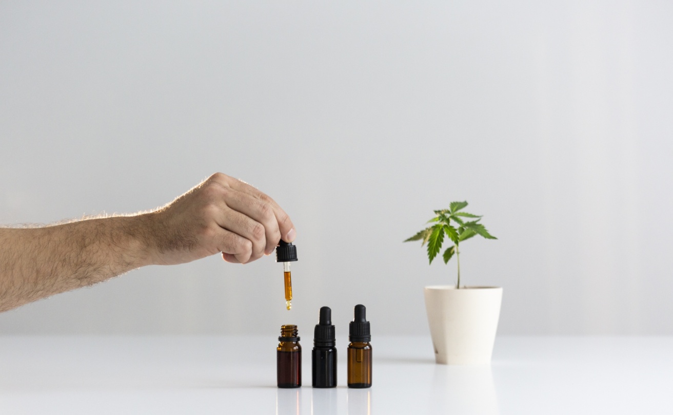 31274226-hand-dropping-cbd-oil-from-pipette-to-the-bottle