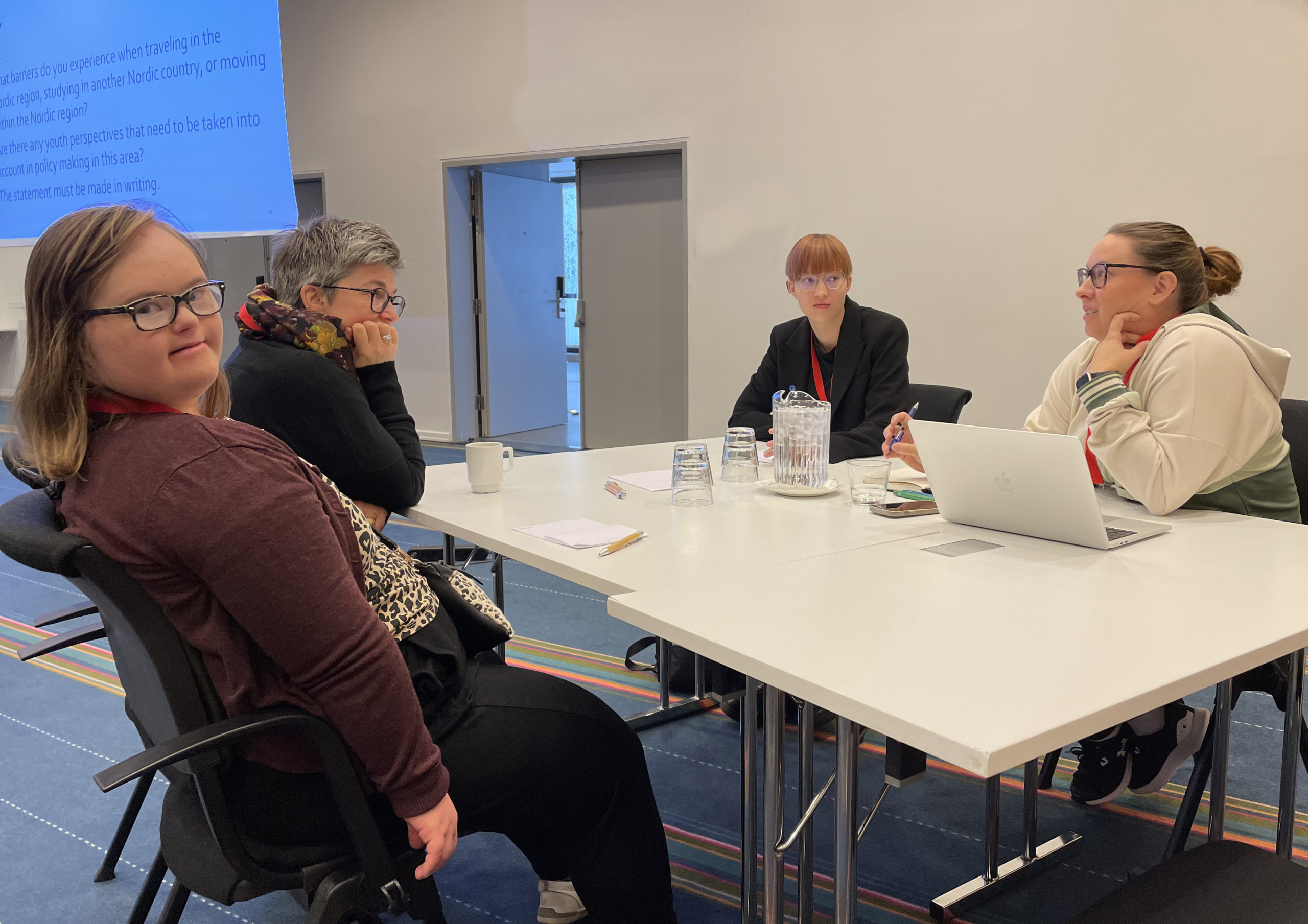 4 women discussiong sitting at a table