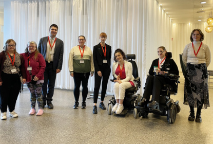 8 people in a group picture inside a hotel lobby
