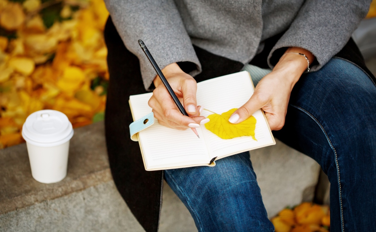Woman's hands close up holding notebook and pencil