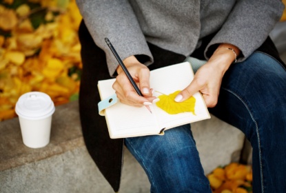 Woman's hands close up holding notebook and pencil
