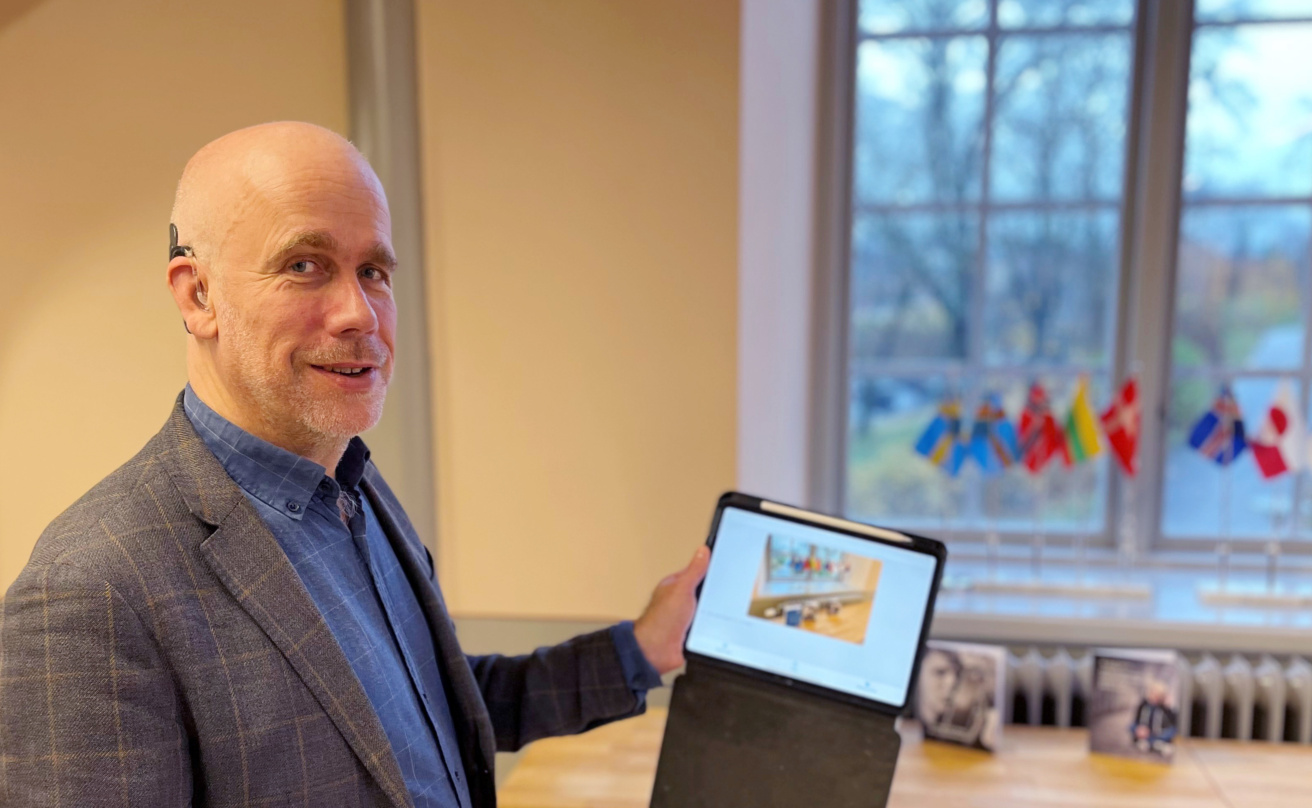 Lars Lindberg standing with an ipad demonstrating a picture narrating app