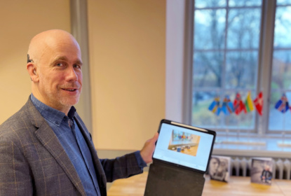 Lars Lindberg standing with an ipad demonstrating a picture narrating app