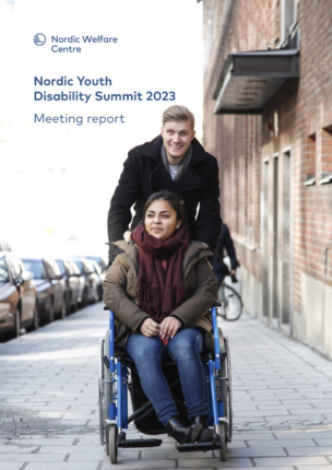 Two young people outsdoors, one is sitting in a wheelchair.